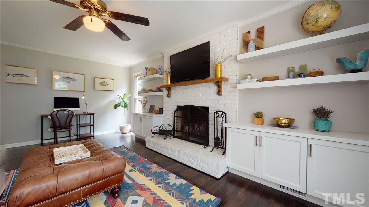 2104 Chrisdale Court Raleigh, NC 27607 - Photo 15 of 29 a living room with furniture a flat screen tv and a fireplace