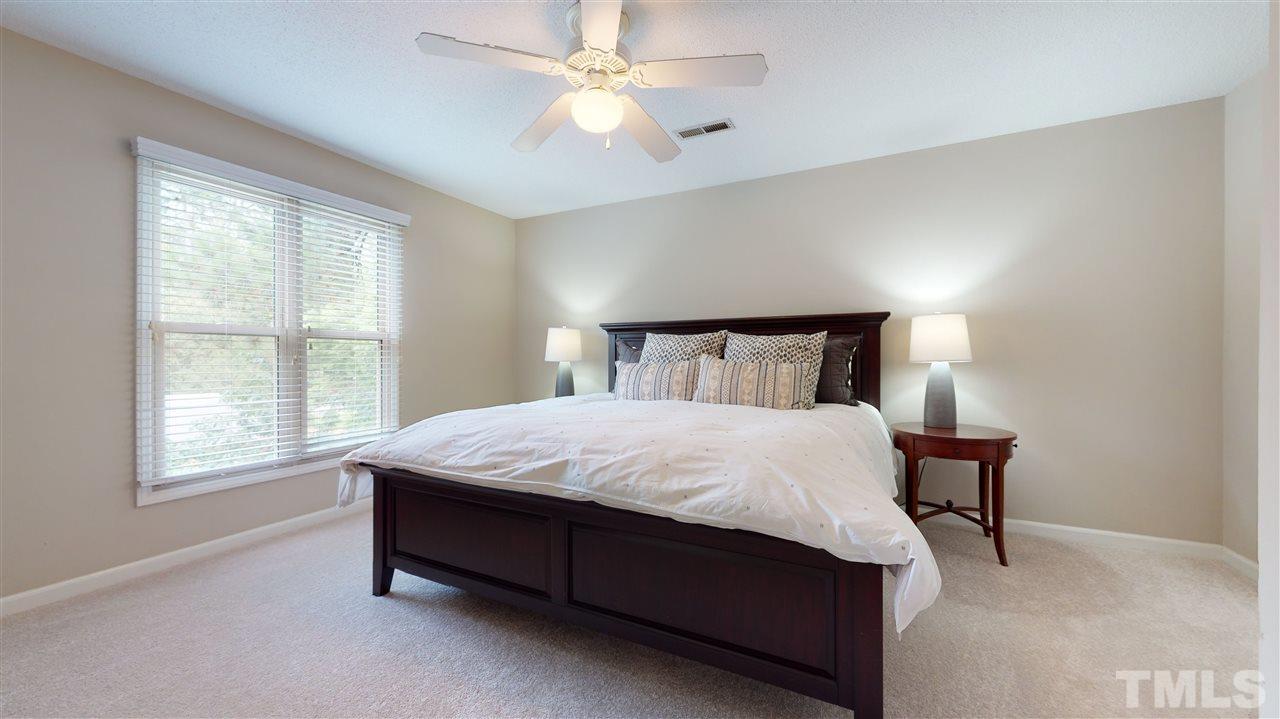 2104 Chrisdale Court Raleigh, NC 27607 - Photo 17 of 29 a large bed sitting in a bedroom next to a window