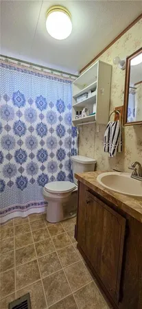 a bathroom with a granite countertop sink a toilet and a mirror