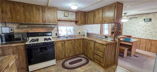a kitchen with a stove sink and cabinets