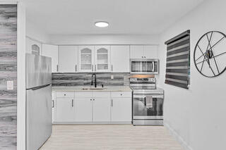 2747 Griffin Road, Unit 13 Fort Lauderdale, FL 33312 - Photo 29 of 37 a kitchen with stainless steel appliances granite countertop a stove a sink and a refrigerator