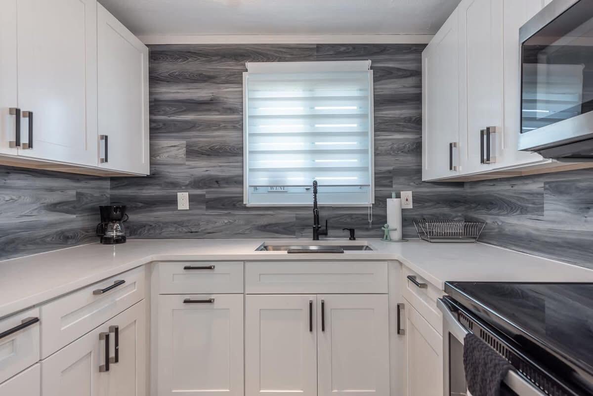 2747 Griffin Road, Unit 13 Fort Lauderdale, FL 33312 - Photo 36 of 37 a kitchen with stainless steel appliances granite countertop a sink a stove and cabinets