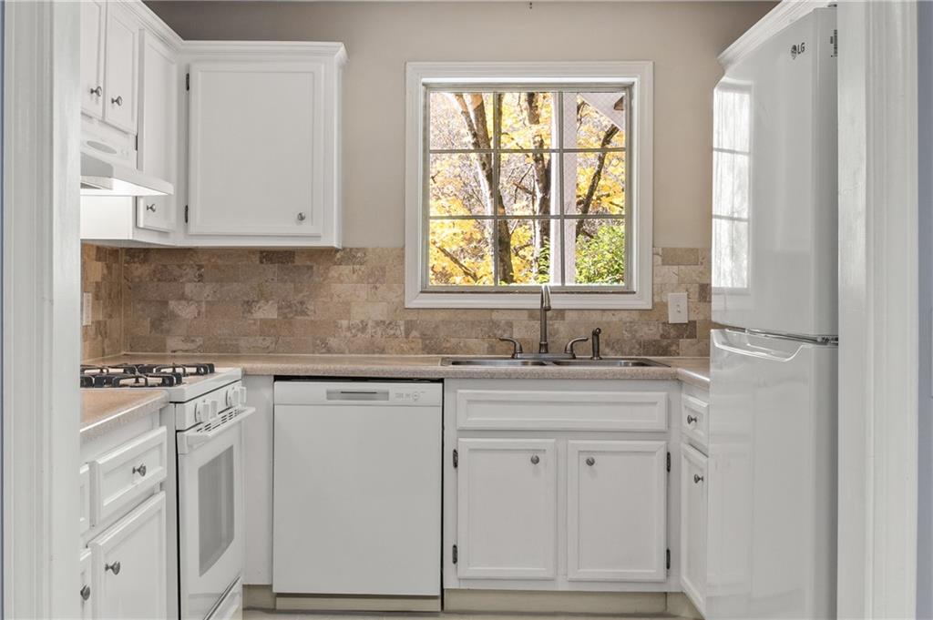 707 Gettysburg Place Atlanta, GA 30350 - Photo 18 of 40 a kitchen with white cabinets and white appliances