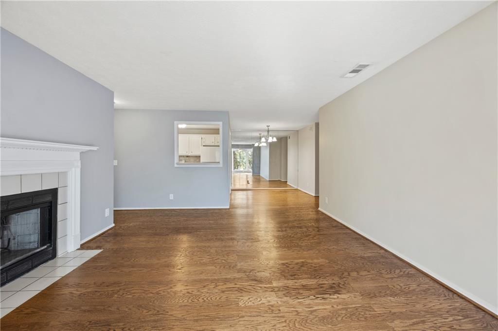 707 Gettysburg Place Atlanta, GA 30350 - Photo 9 of 40 a view of an empty room with wooden floor fireplace and a window