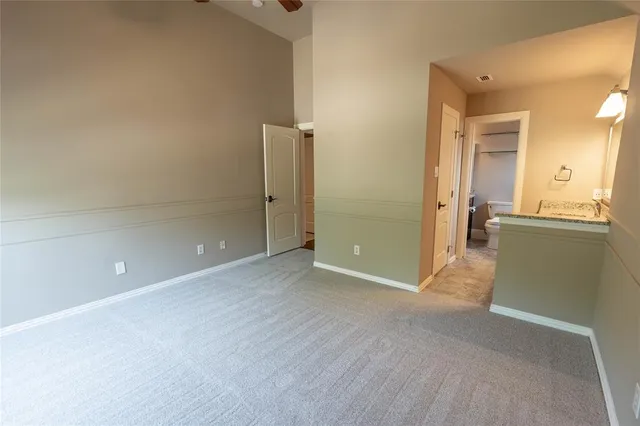 an empty room with a bathroom and mirror