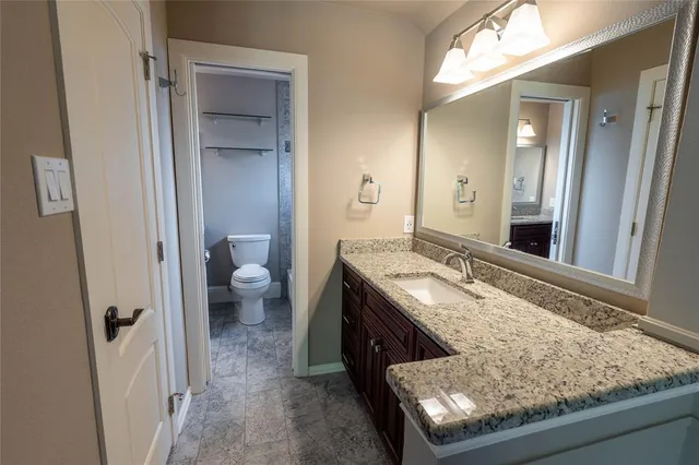 a bathroom with a granite countertop sink and a mirror