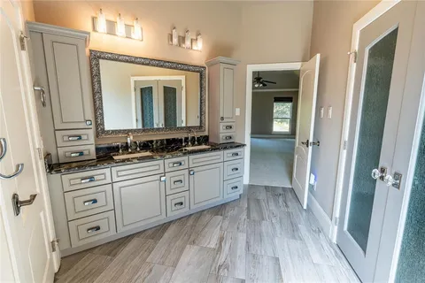 a spacious bathroom with a granite countertop sink toilet and shower
