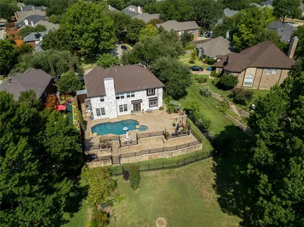 an aerial view of a house with swimming pool and outdoor seating