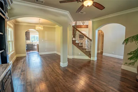 a view of a hallway with wooden floor stairs and a chandelier