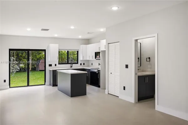 a large white kitchen with a large window