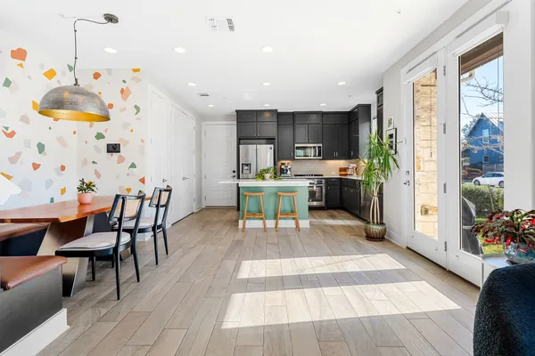 a living room with stainless steel appliances kitchen island granite countertop furniture wooden floor and a rug
