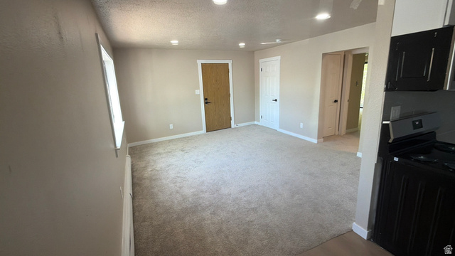 647 Swenson Avenue, Unit 4 Springville, UT 84663 - Photo 6 of 14 Kitchen featuring black electric range oven, a textured ceiling, recessed lighting, and light colored carpet