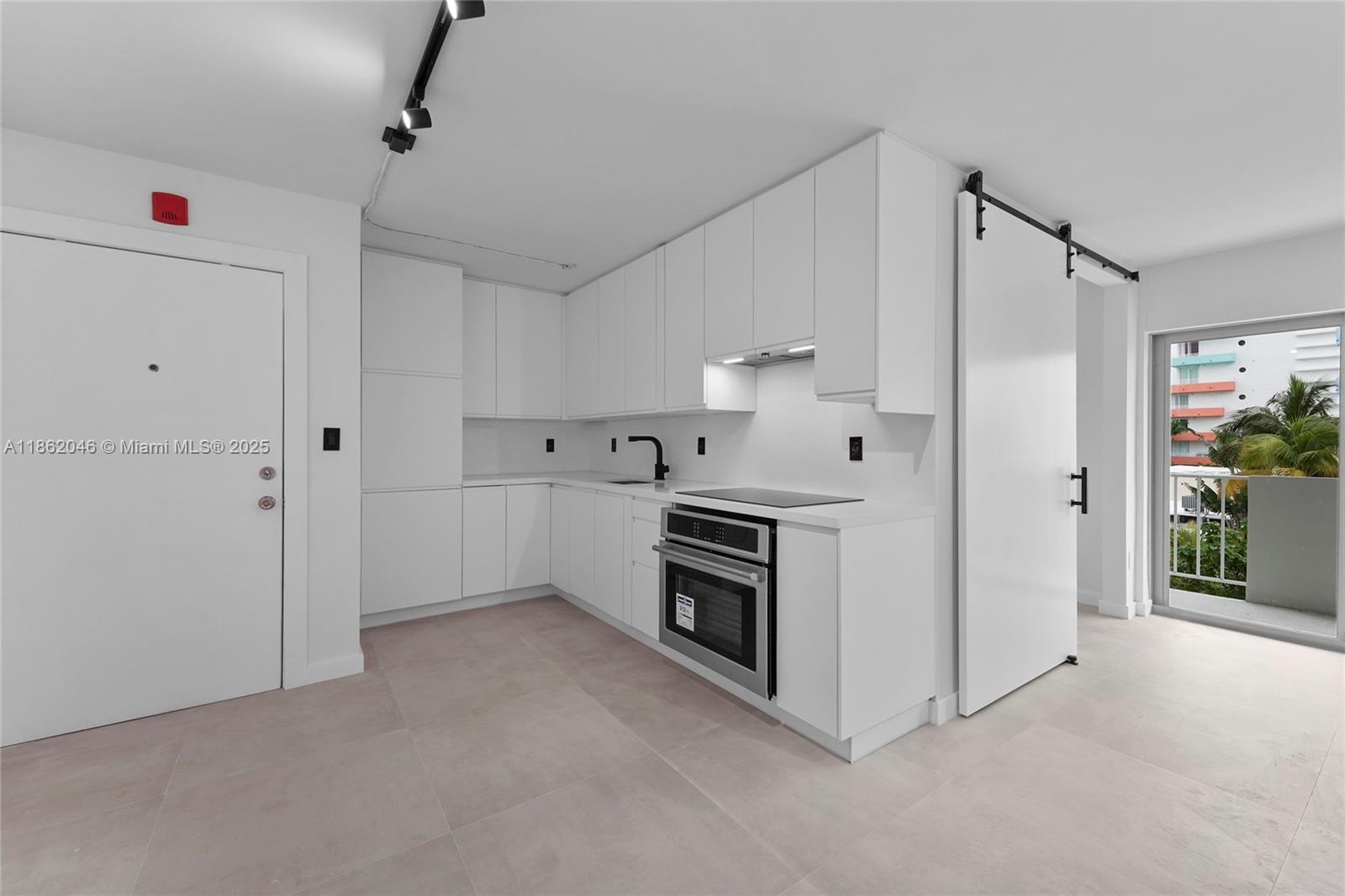 240 Collins Avenue, Unit 4A Miami Beach, FL 33139 - Photo 1 of 16 a kitchen with white cabinets and white appliances