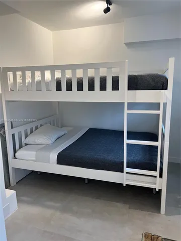 a bed sitting in a bedroom next to a cabinet