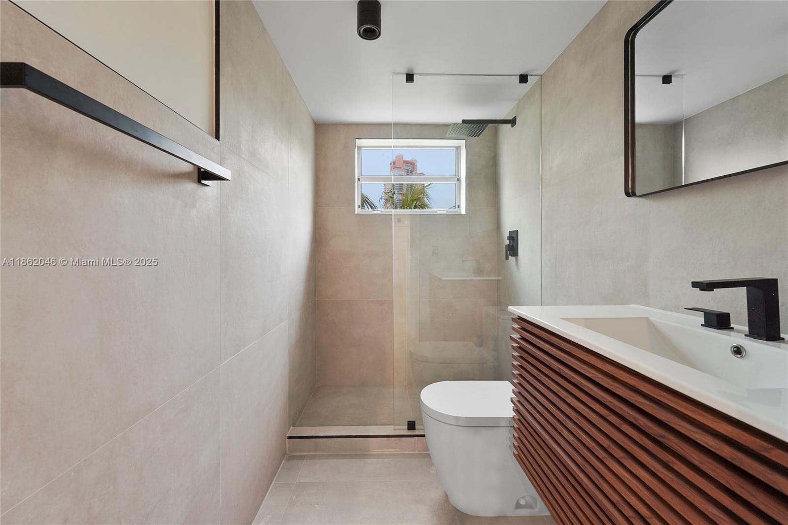 240 Collins Avenue, Unit 4A Miami Beach, FL 33139 - Photo 2 of 16 a bathroom with a sink a toilet and shower