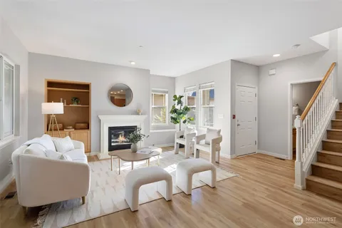 a living room with furniture a fireplace and a potted plant
