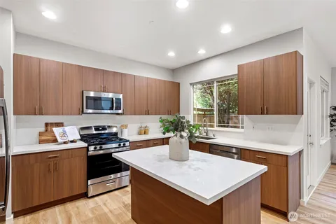a kitchen with a stove a sink dishwasher and a refrigerator