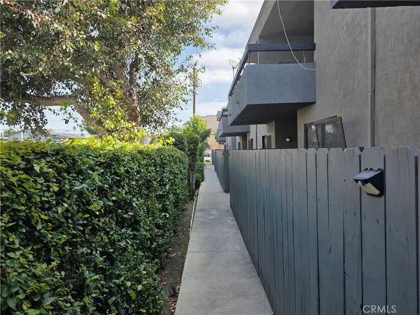 a view of a pathway of a house with wooden fence