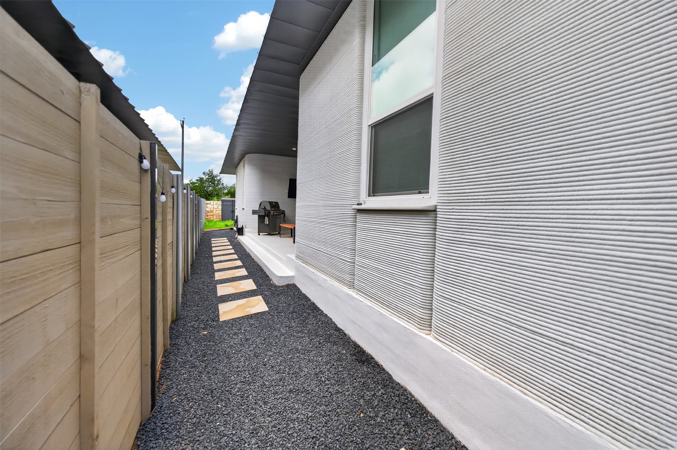 308 Painted Sunset Drive Georgetown, TX 78628 - Photo 18 of 26 Modern exterior wall with horizontal textured finish, a fixed window, and an elevated concrete patio