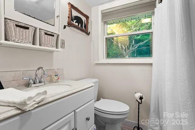 a bathroom with a granite countertop sink mirror and toilet