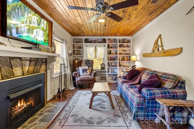 a living room with furniture a fireplace and a floor to ceiling window