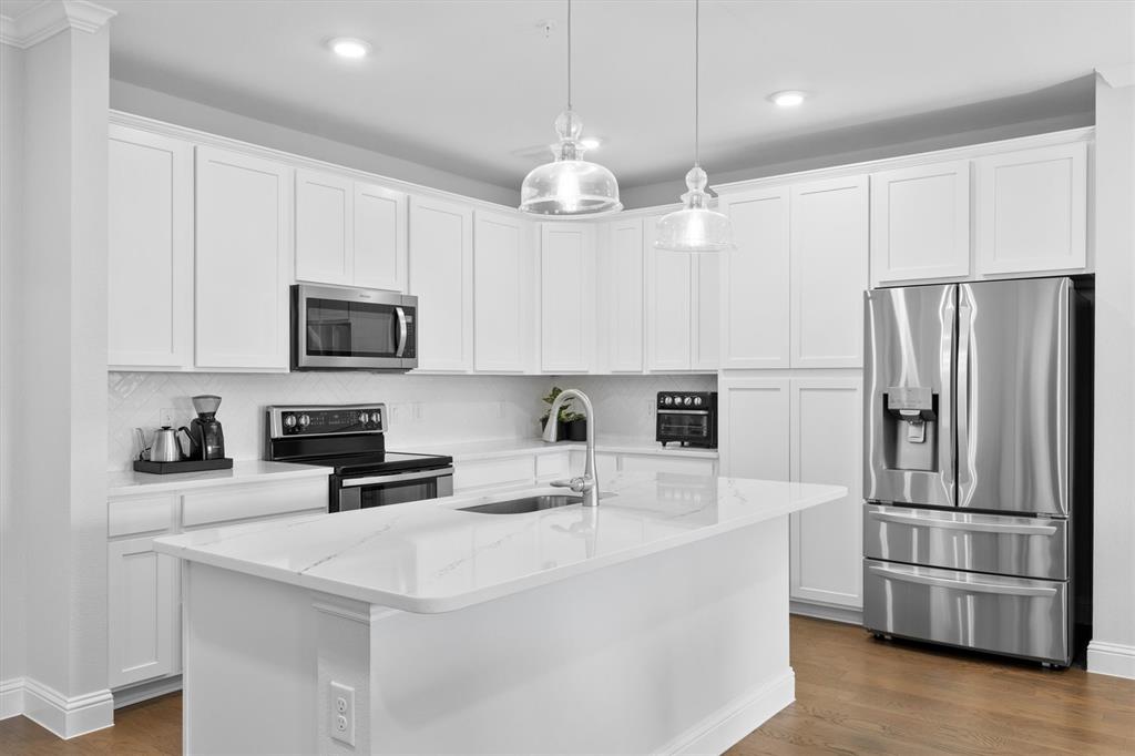 651 Watters Road, Unit 4403 Allen, TX 75013 - Photo 6 of 37 a kitchen with stainless steel appliances a microwave a sink and a refrigerator