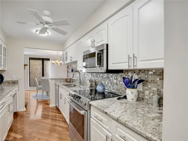 a kitchen with stainless steel appliances granite countertop a sink and cabinets