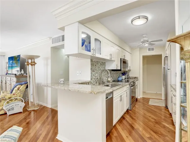 a large white kitchen with a lot of counter space and a refrigerator