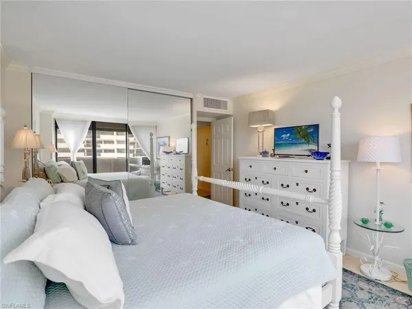 a bedroom with a large bed and flat screen tv