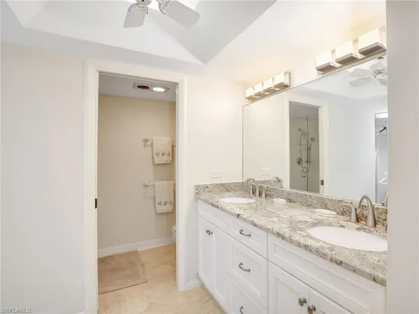 a bathroom with a granite countertop sink toilet and shower