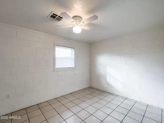 an empty room with closet and a chandelier fan