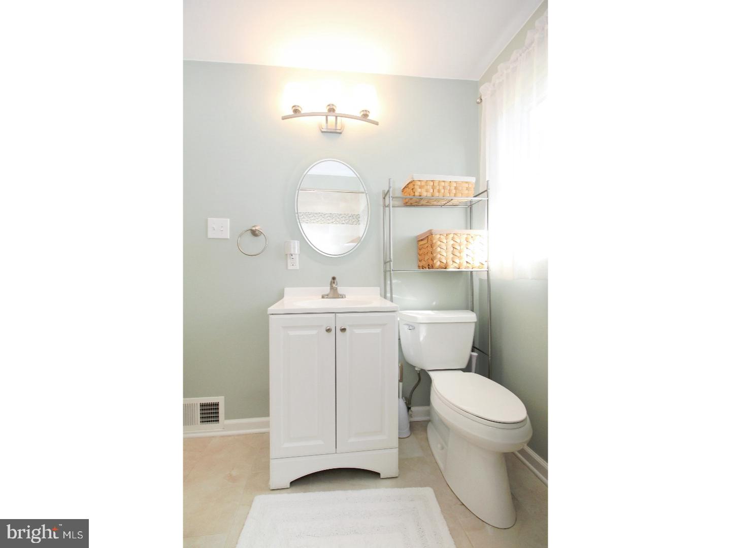 735 Rhoads Drive Springfield, PA 19064 - Photo 15 of 25 a bathroom with a toilet a sink a mirror and vanity