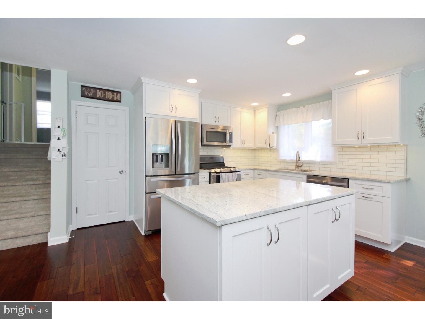 735 Rhoads Drive Springfield, PA 19064 - Photo 9 of 25 a kitchen with a sink a stove a refrigerator and white cabinets