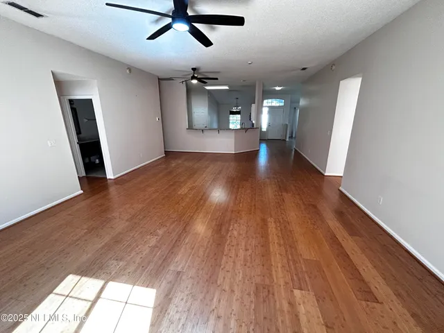 a view of empty room with wooden floor