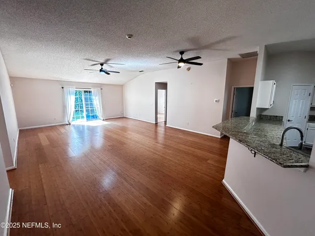 a kitchen with granite countertop a stove a sink and a refrigerator