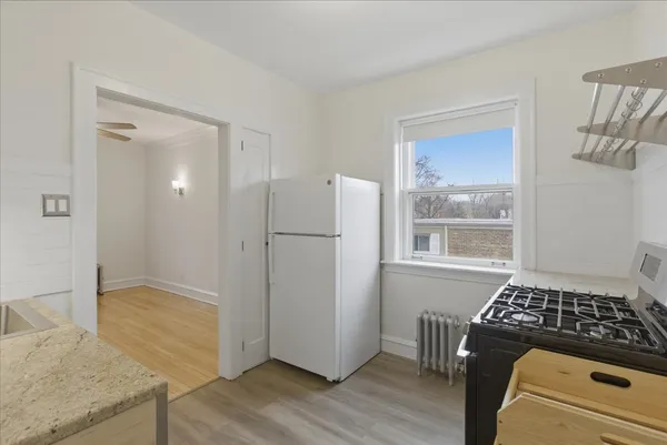 a kitchen with granite countertop a refrigerator and a stove top oven