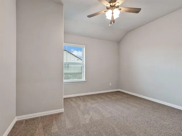 a view of an empty room and chandelier fan