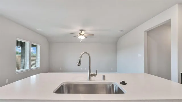 a room with stainless steel appliances kitchen island granite countertop a refrigerator and a stove top oven