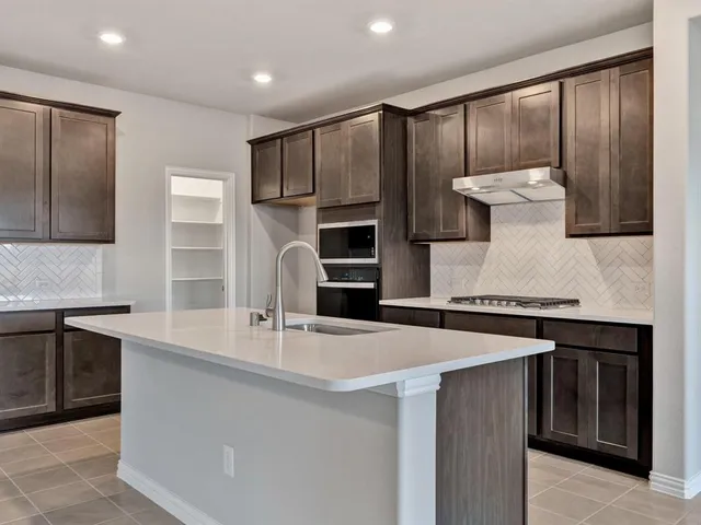 a kitchen with stainless steel appliances granite countertop a sink a stove and a refrigerator