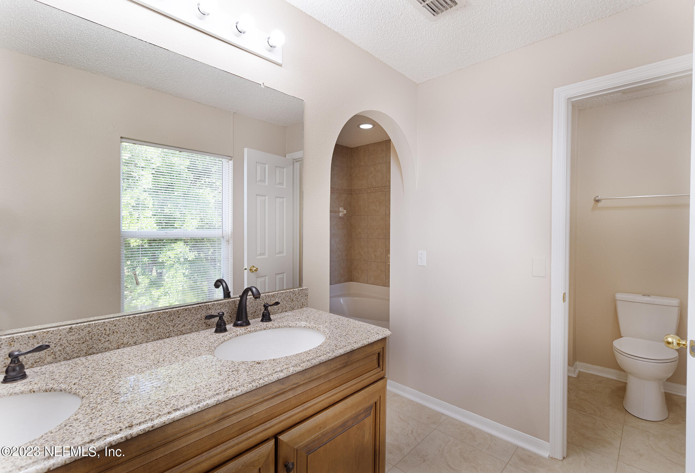 1490 Seawolf Trail Jacksonville, FL 32221 - Photo 25 of 36 a bathroom with a granite countertop sink a toilet and a window