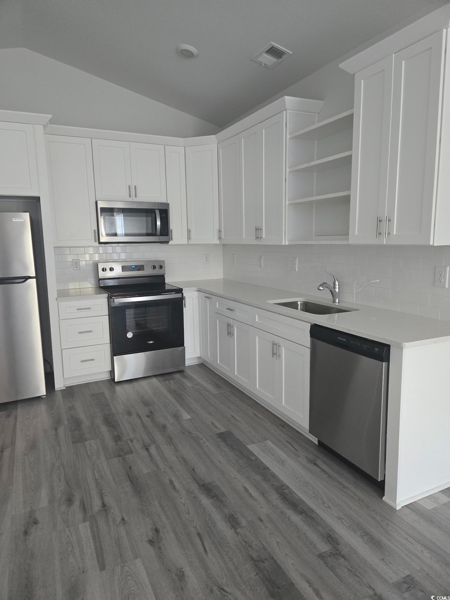 2027 6th Avenue Conway, SC 29526 - Photo 3 of 7 Kitchen featuring lofted ceiling, stainless steel appliances, white cabinets, and backsplash