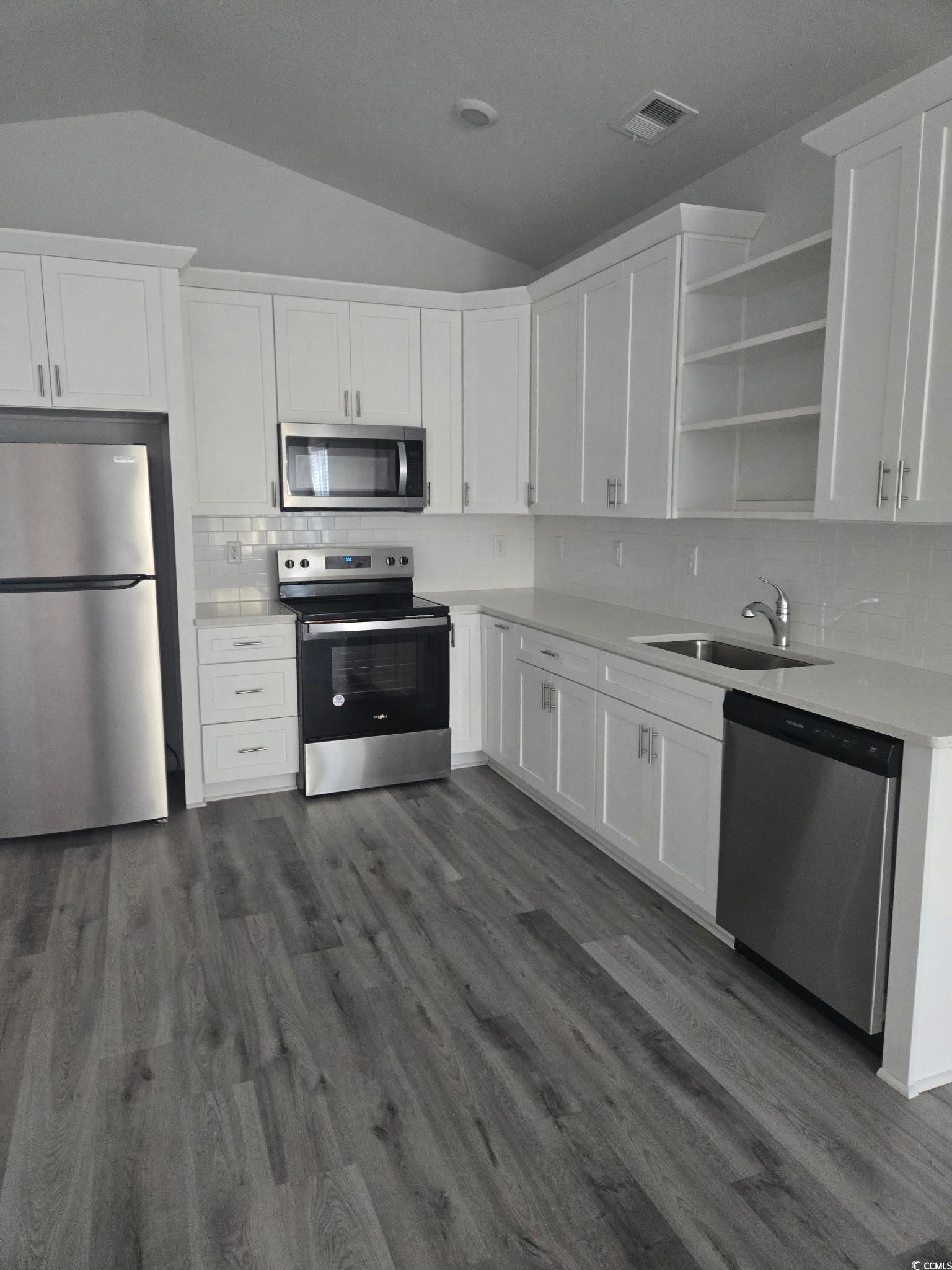 2027 6th Avenue Conway, SC 29526 - Photo 4 of 7 Kitchen with decorative backsplash, appliances with stainless steel finishes, lofted ceiling, and white cabinets