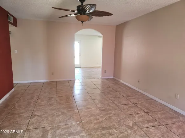 an empty room with a ceiling fan and carpet