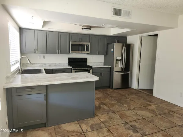 a kitchen with stainless steel appliances a refrigerator sink and microwave