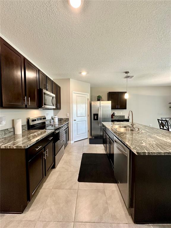 19 Hickory Course Radiel Ocala, FL 34472 - Photo 7 of 22 a large kitchen with stainless steel appliances granite countertop a stove top oven a sink dishwasher a dining table and chairs with wooden floor