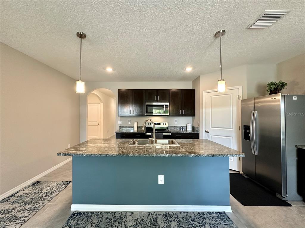 19 Hickory Course Radiel Ocala, FL 34472 - Photo 8 of 22 a kitchen with kitchen island a counter top space a sink cabinets and stainless steel appliances