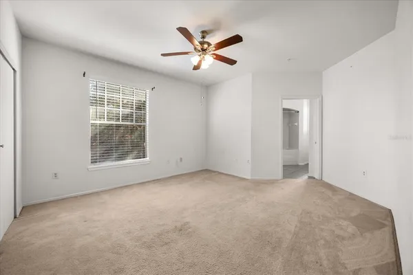 an empty room with closet and ceiling fan