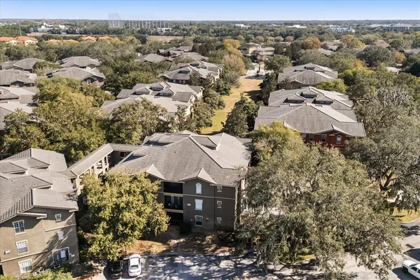 an aerial view of residential houses with outdoor space and trees