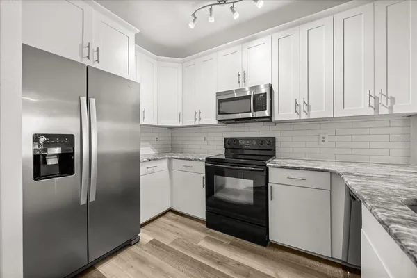 a metallic refrigerator freezer sitting in a kitchen