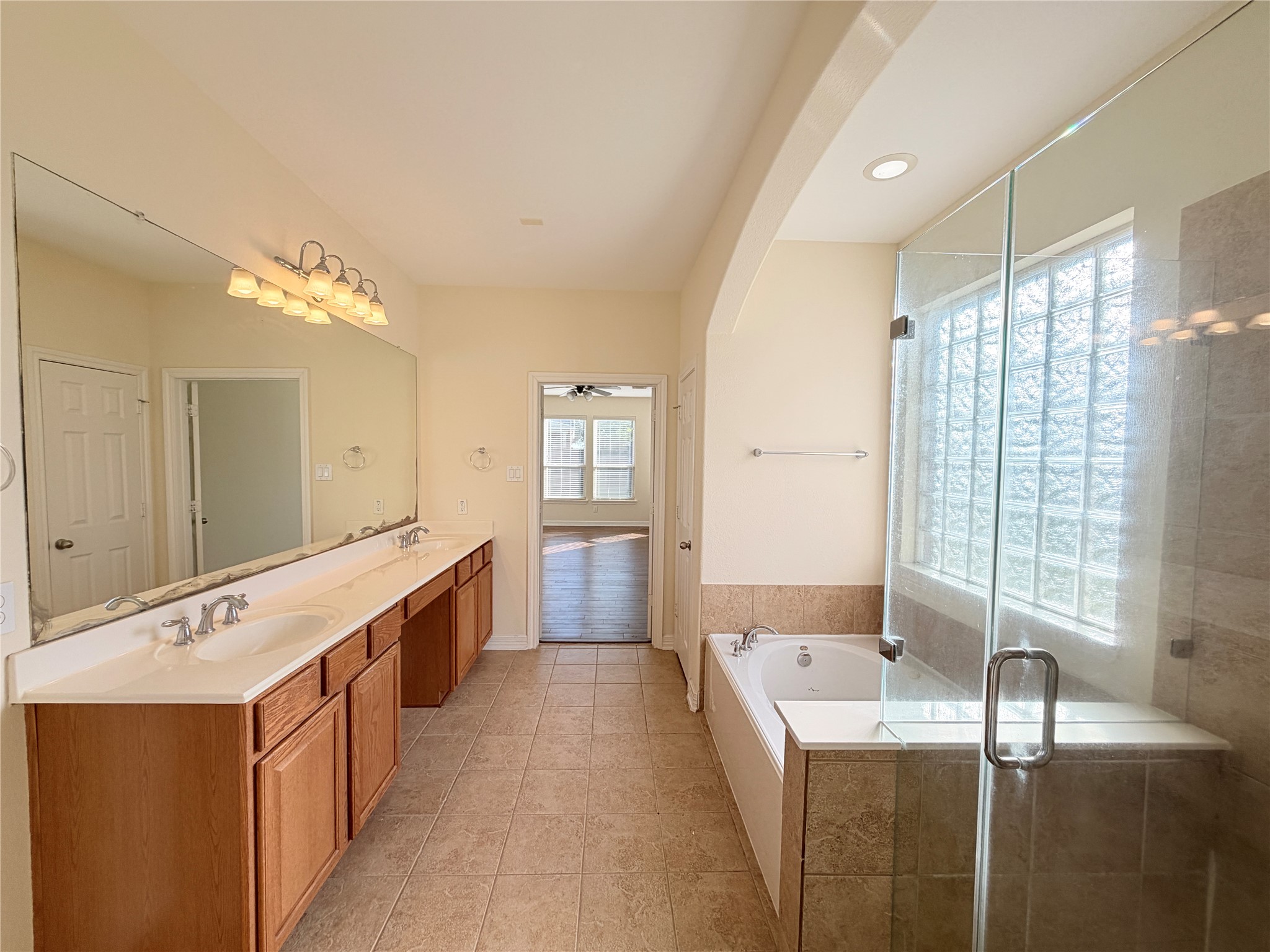 28015 Silverstream Court Fulshear, TX 77441 - Photo 18 of 33 a large bathroom with a double vanity sink a large mirror and a bathtub